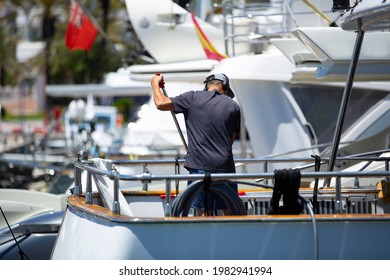 Maintenance Worker Cleaning A Yacht Docked On The Dock