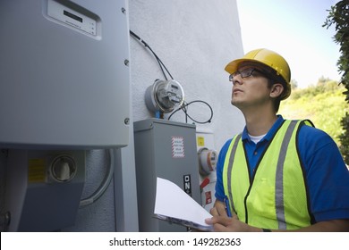 Maintenance Worker Reading Meter Of Solar Generation Unit In Los Angeles; California