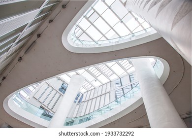 Mainz, Germany - 10 March, 2021: Atrium. Interior Of Modern Public Building With Roof Of Glass And Columns That Extend Upwards. View From Below With Skylight. Architecture And Building Construction