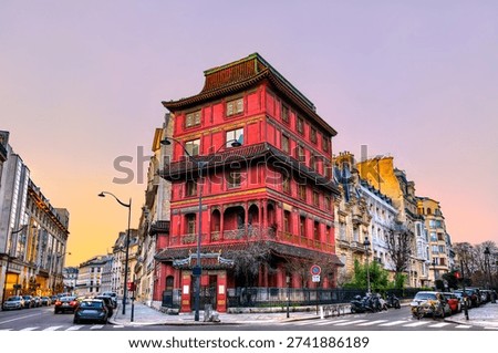 Maison Loo in Paris 8th district. Historic red pagoda building features Chinese architecture at the corner of Rue de Courcelles and Rue Rembrandt at sunset