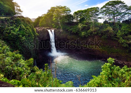 Majesitc Rainbow Falls waterfall in Hilo, Wailuku River State Park, Hawaii. The falls flows over a natural lava cave, the mythological home to Hina, an ancient Hawaiian goddess. 