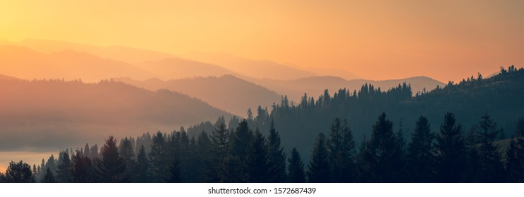 Majestic autumn scenery of foggy valley at Carpathian mountain range at early morning sunrise. Beautiful tonal perspective wide angle panorama. - Powered by Shutterstock