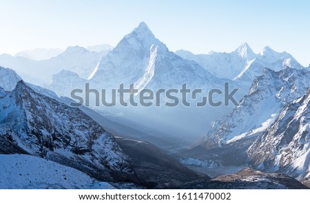 Majestic blue mountain ridges in the morning light; delightful pyramid of Ama Dablam peak (6814 m) in Nepal, Himalayas