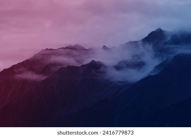 Majestic dark Dolomites mountains peaks are surrounded by fog