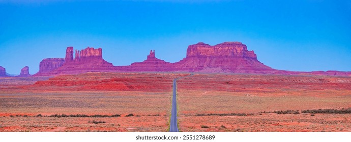 Majestic desert landscape of Monument Valley in Arizona under a clear blue sky. A long road leads toward iconic red rock formations, capturing the essence of the American Southwest's natural beauty. - Powered by Shutterstock