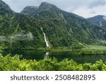 Majestic Doubtful Sound fjord in Fiordland National Park, South Island, New Zealand. Misty mountains, lush forests, and serene waters create a tranquil, untouched nature escape