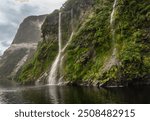 Majestic Doubtful Sound fjord in Fiordland National Park, South Island, New Zealand. Misty mountains, lush forests, and serene waters create a tranquil, untouched nature escape