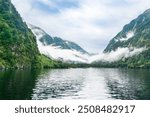 Majestic Doubtful Sound fjord in Fiordland National Park, South Island, New Zealand. Misty mountains, lush forests, and serene waters create a tranquil, untouched nature escape