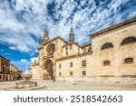 The majestic facade of the Cathedral in El Burgo de Osma showcases intricate architecture against a beautiful sky in Soria, Spain.