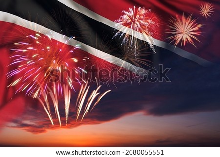Majestic fireworks in evening sky and flag of Trinidad and Tobago for Independence day or National Holiday