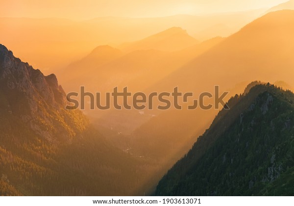 Majestic golden sunset with\
sunny beams in big mountain landscape. High Tatras national park,\
Poland