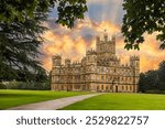 Majestic Highclere Castle in England with a beautiful sunset sky and light rays.