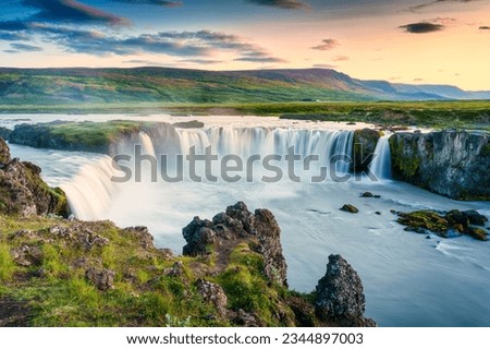 Majestic landscape of Godafoss waterfall or waterfall of the gods flowing and colorful sunset sky on Skjalfandafljot river in summer at Northern Iceland