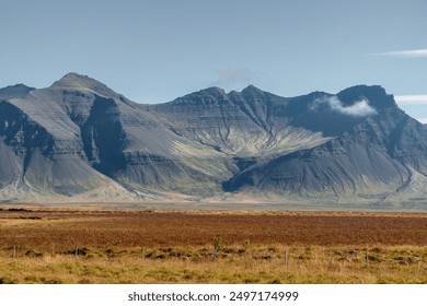 Majestic mountain range with rugged peaks and valleys under a clear blue sky. - Powered by Shutterstock