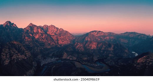 Majestic mountains bathed in a rosy dusk, towering over winding rivers below, their rugged forms softened by the gentle glow of the fading sky. - Powered by Shutterstock