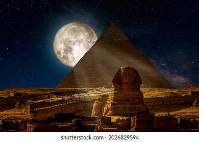 Majestic night scene with Great Pyramid, Guardian Sphinx and huge Moon in starry dark blue sky in Giza, Cairo, Egypt