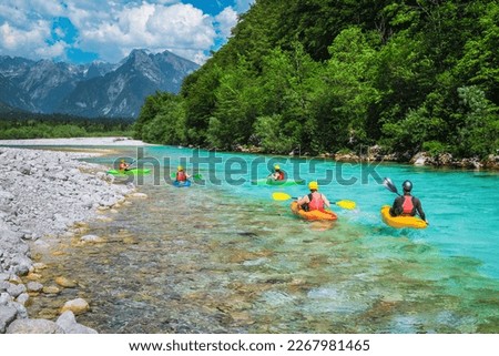 Majestic rafting and kayaking place on the river. Active kayakers in colorful life jacket paddling and exercising on the turquoise color Soca river, Bovec, Triglav National Park, Slovenia, Europe