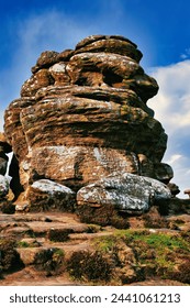 Majestic rock formation under blue sky with clouds, showcasing natural erosion and geological layers at Brimham Rocks, in North Yorkshire
