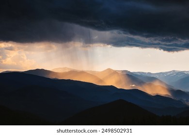 Majestic scene of a heavy downpour illuminated by the rays of the sun. Unique natural phenomenon. Location place Carpathian mountains, Ukraine, Europe. Photo wallpaper. Discovery the beauty of earth.