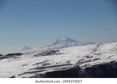 Majestic snow-capped mountain range under clear blue sky, a breathtaking winter wonderland - Powered by Shutterstock