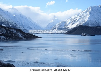 Majestic snow-capped mountains towering over a tranquil lake filled with floating ice in New Zealand. The vast landscape offers a breathtaking view of nature’s raw beauty. - Powered by Shutterstock