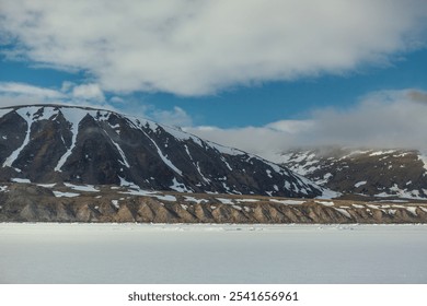 Majestic Snow-Capped Mountains Under Cloudy Sky in Arctic - Powered by Shutterstock