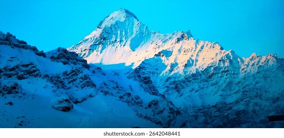 Majestic snow-covered mountain peak glowing in sunlight under a clear blue sky, symbolizing nature's purity, peace, and elevation.
						#Hashtags: #SnowMountain #WinterWonders #Himalayas #MountainView #Sno
