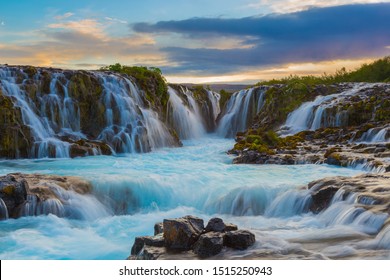 Majestic summer sunrise on Bruarfoss Waterfall.
The 'Iceland’s Bluest Waterfall.' Blue water flows over stones. Midnight sun of Iceland. Visit Iceland. Beauty world.