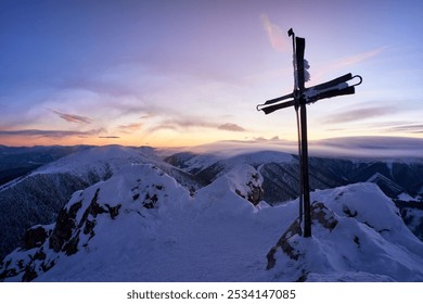 Majestic sunset over snowy mountain peak with cross silhouette, creating peaceful winter landscape - Powered by Shutterstock