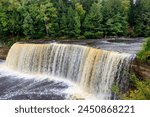 The majestic Tahquamenon Upper Falls captivate the viewer with their powerful cascade of foaming water. Surrounded by lush greenery nickname Root Beer Falls.