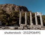 The majestic Temple of Athena in Priene, an ancient Greek city in Turkey. The iconic marble columns stand tall against the backdrop of a serene landscape, 