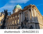 Majestic view of Buda Castle’s ornate facade and Matthias Fountain under golden sunlight in Budapest, Hungary, showcasing historic European architecture and artistic sculpture.