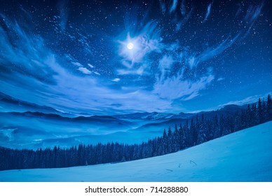 Majestic Winter Night In A Mountain Valley With Full Moon In A Starry Sky.