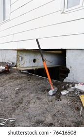 Major Reno: Sledgehammer Against Strong Steel Beam Inserted For Support To Lift And Old House With White Siding To Change The Damaged Concrete Block Foundation.