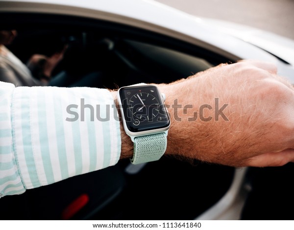 MAJORCA, SPAIN - MAY 10, 2018: Man\
checking time on Apple Watch before entering car - pov\
