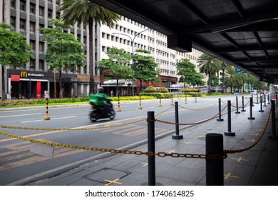 Makati, Manila, Philippines - May, 26, 2020: Empty Ayala Avenue With Delivery Motorcycle Biker Moving Fast. Coronavirus Covid Quarantine Concept 