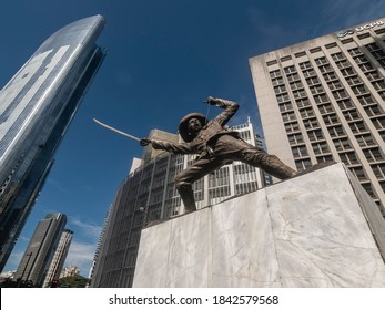 Makati, Metro Manila, Philippines - Oct 2020: Pio Del Pilar Monument Monument At Ayala Triangle, By The Corner Of Paseo De Roxas And Makati Avenue. Wide Angle Shot, Flanked By Modern Office Buildings.