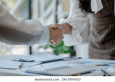 Make agreements with business partners, Success in negotiating and entering into business contracts, Meeting commitments in a meeting room at the office, Business people shaking hands in office,