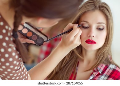 Make Up Artist Doing Professional Make Up Of Young Woman