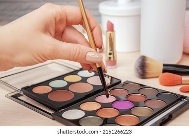 Make up artist picks shine shimmer pigment from bright colorful eyeshadow palette with a brush. Professional makeup, beauty salon. Selective focus. - Powered by Shutterstock - Get 15% off with code: PIKWIZARD15