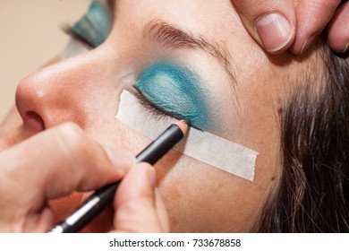 Make up artist using masking tape to create cat eyes - Shutterstock ID 733678858