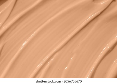 Make up base, cream textured background. Beige nude liquid foundation texture, concealer smear smudge drop. Closeup macro. Cosmetic tonal makeup moisturizer, bb cream swatch sample.