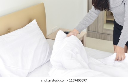 Make a bed, close up young woman holding bed sheet, working in the hotel concept - Shutterstock ID 1159405897