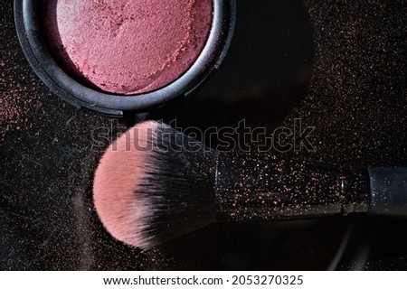 Make up brush and blush for the face on black background