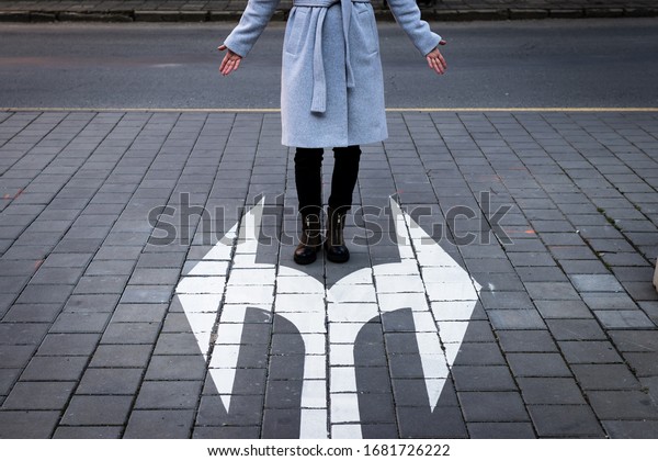 Make choice which way to\
go. Decision concept with directional arrow sign and woman standing\
at road