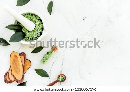 Make cosmetics with tea tree essential oil. Homemade cosmetics. Fresh tea tree leaves, mortar and pestel, cosmetics on white stone background top view border copy space
