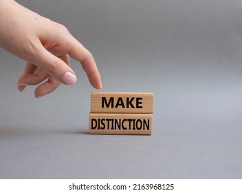 Make distinction symbol. Concept words make distinction on wooden blocks. Beautiful grey background. Businessman hand. Business and make distinction concept. Copy space. - Shutterstock ID 2163968125