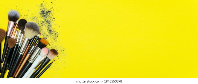 Make up the essentials. A set of professional makeup brushes and cosmetics on a yellow background. Space for your text or logo. Perfect for a beauty blog. Flatly, horizontal. Banner. Copy space.