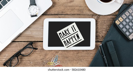 Make it Happen note on office desk with electronic devices, computer and paper, wood table from above, concept image for blog title or header image.