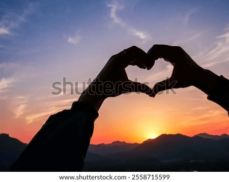Make a heart shape with your hands in the middle of the beautiful sunset sky in west (Xihu),located in Hangzhou city of china